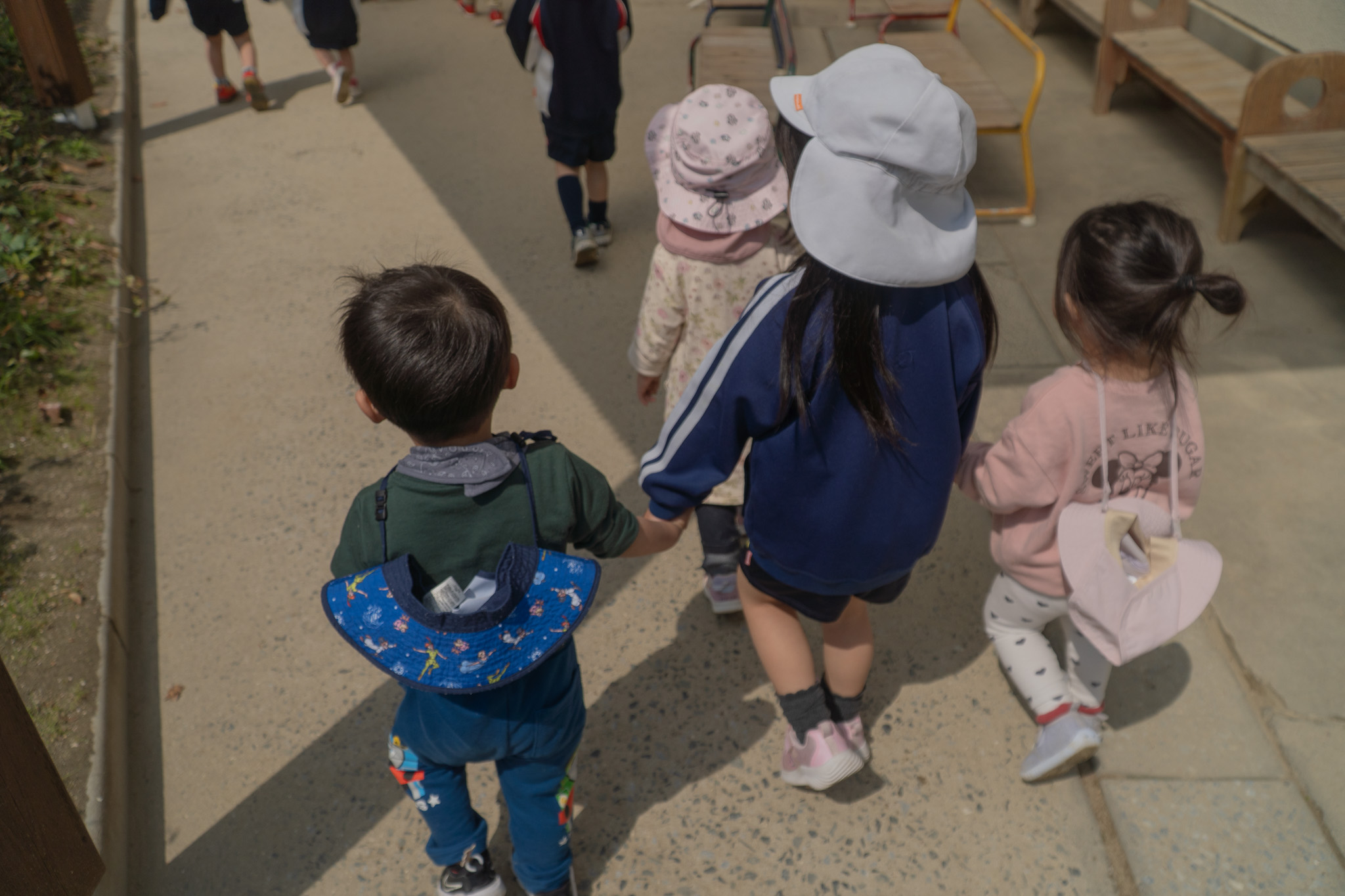 園内を歩く子どもたちの後ろ姿