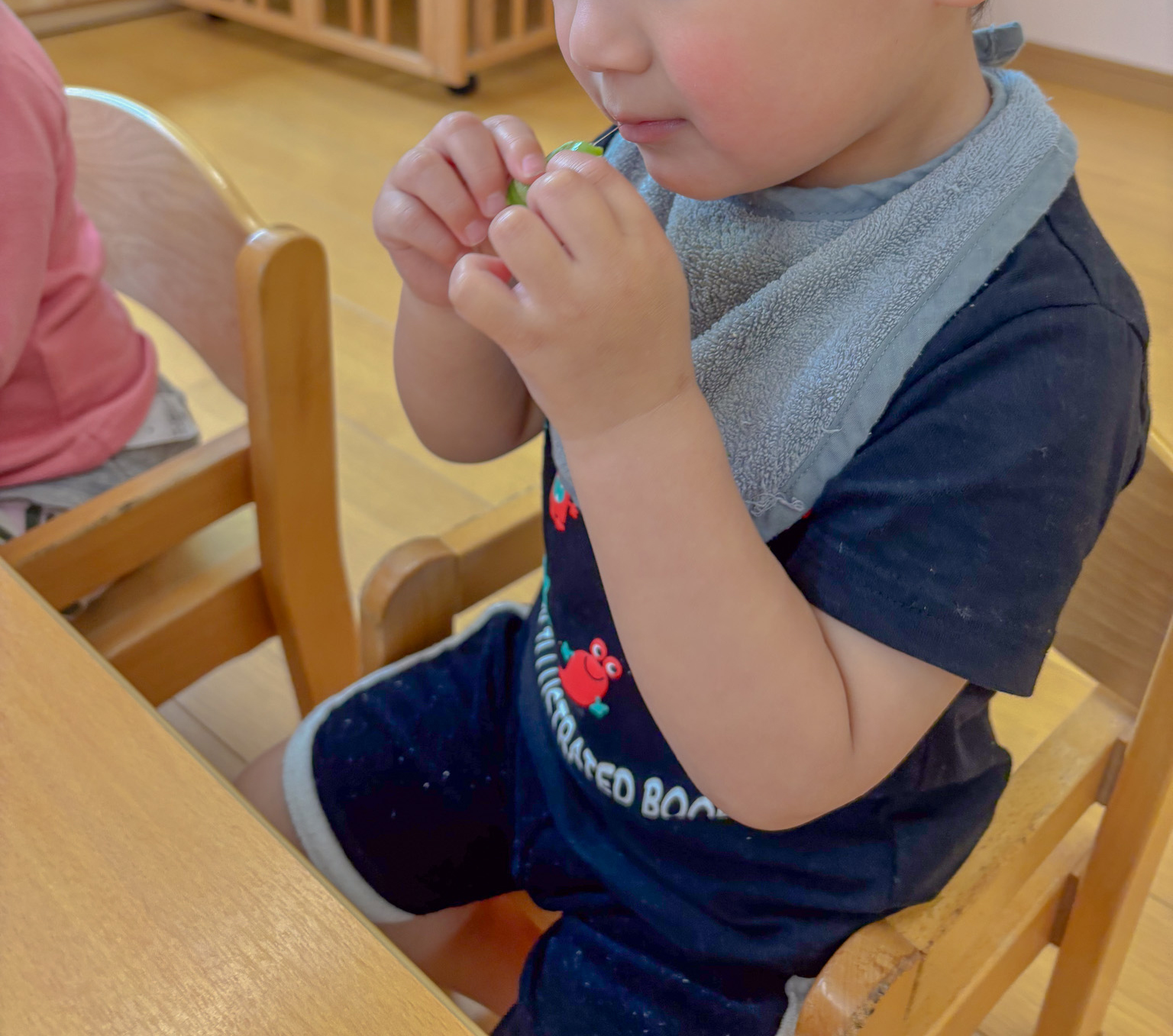 そらまめを手に持ち、パクリと食べる男の子