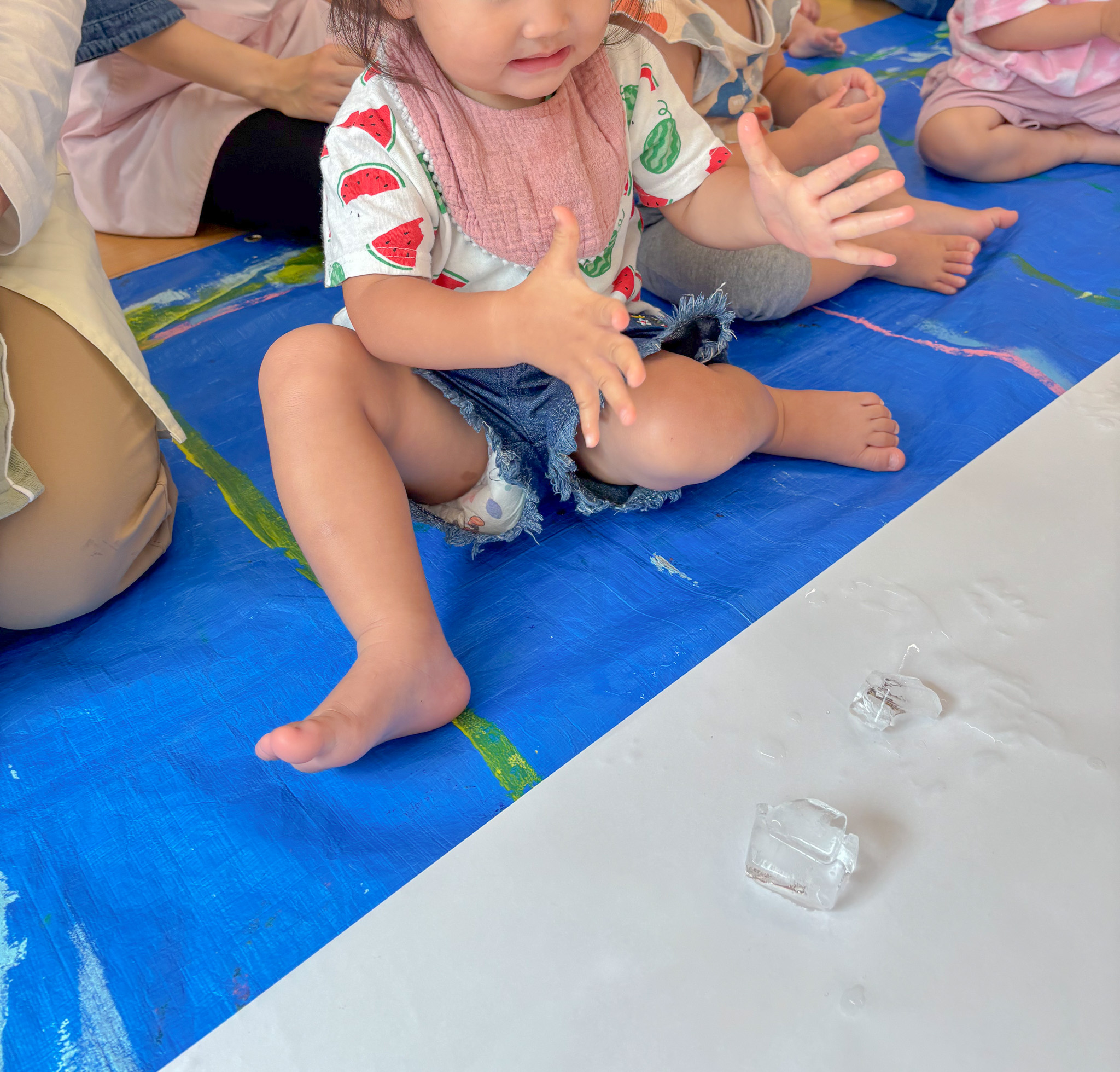 透明な氷に手を伸ばす子ども