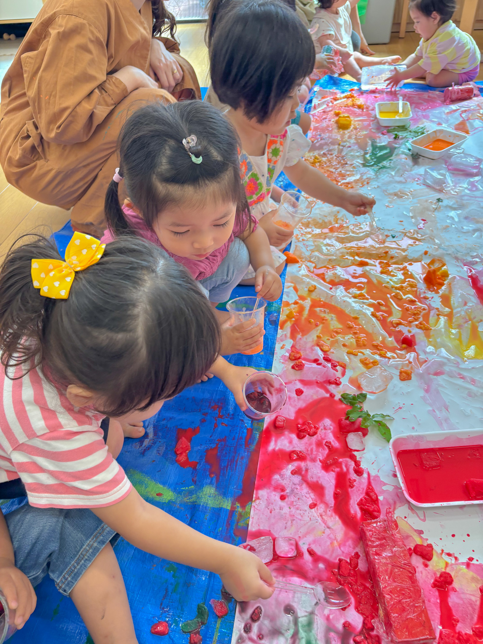 スプーンですくって塗る子ども