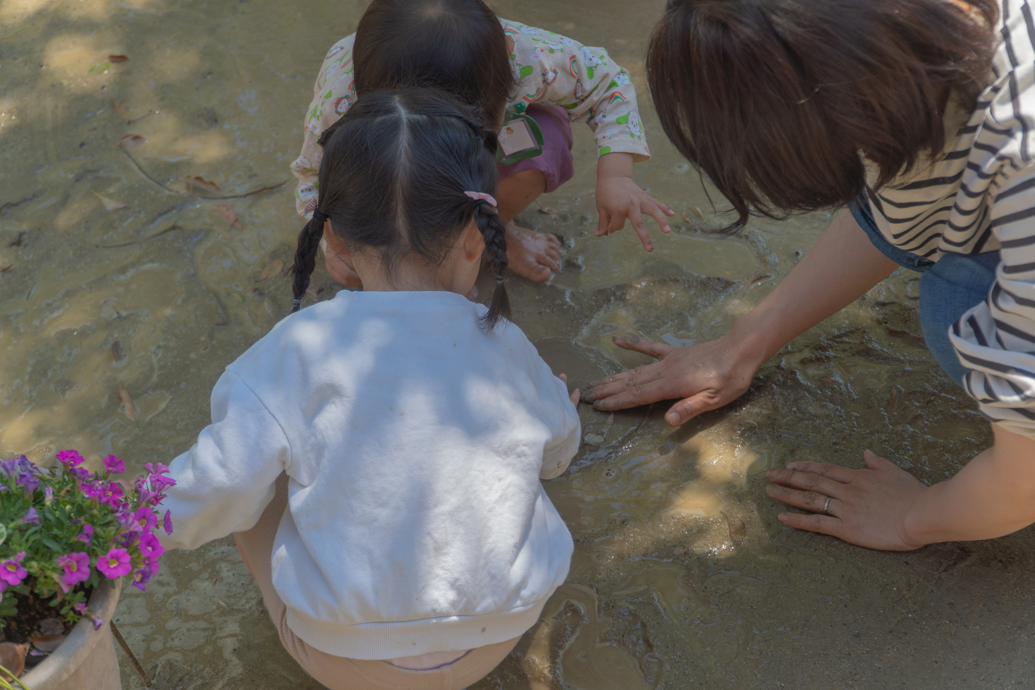 先生と一緒に泥の感触を楽しむ