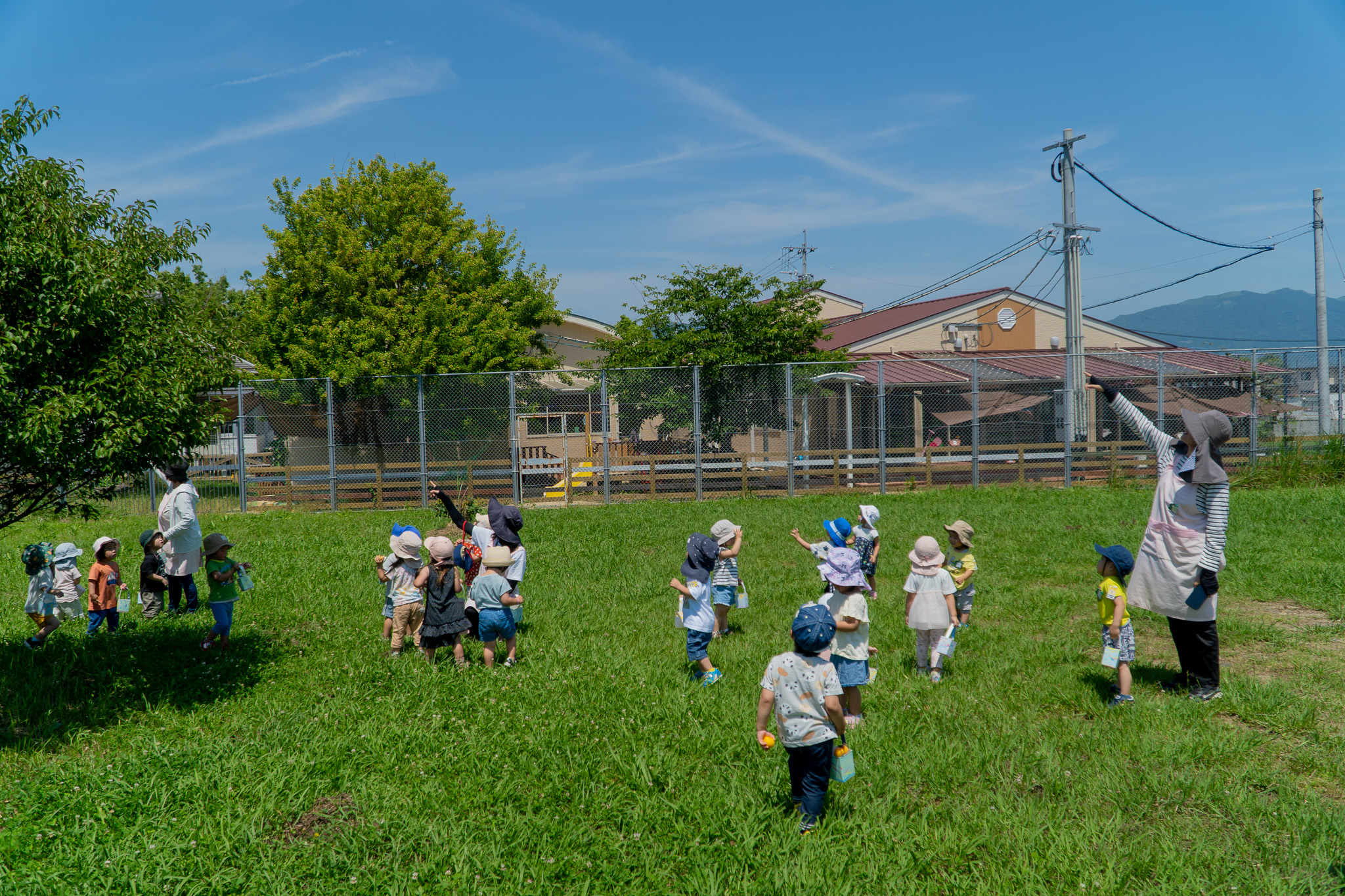 先生と空を見上げる子どもたち