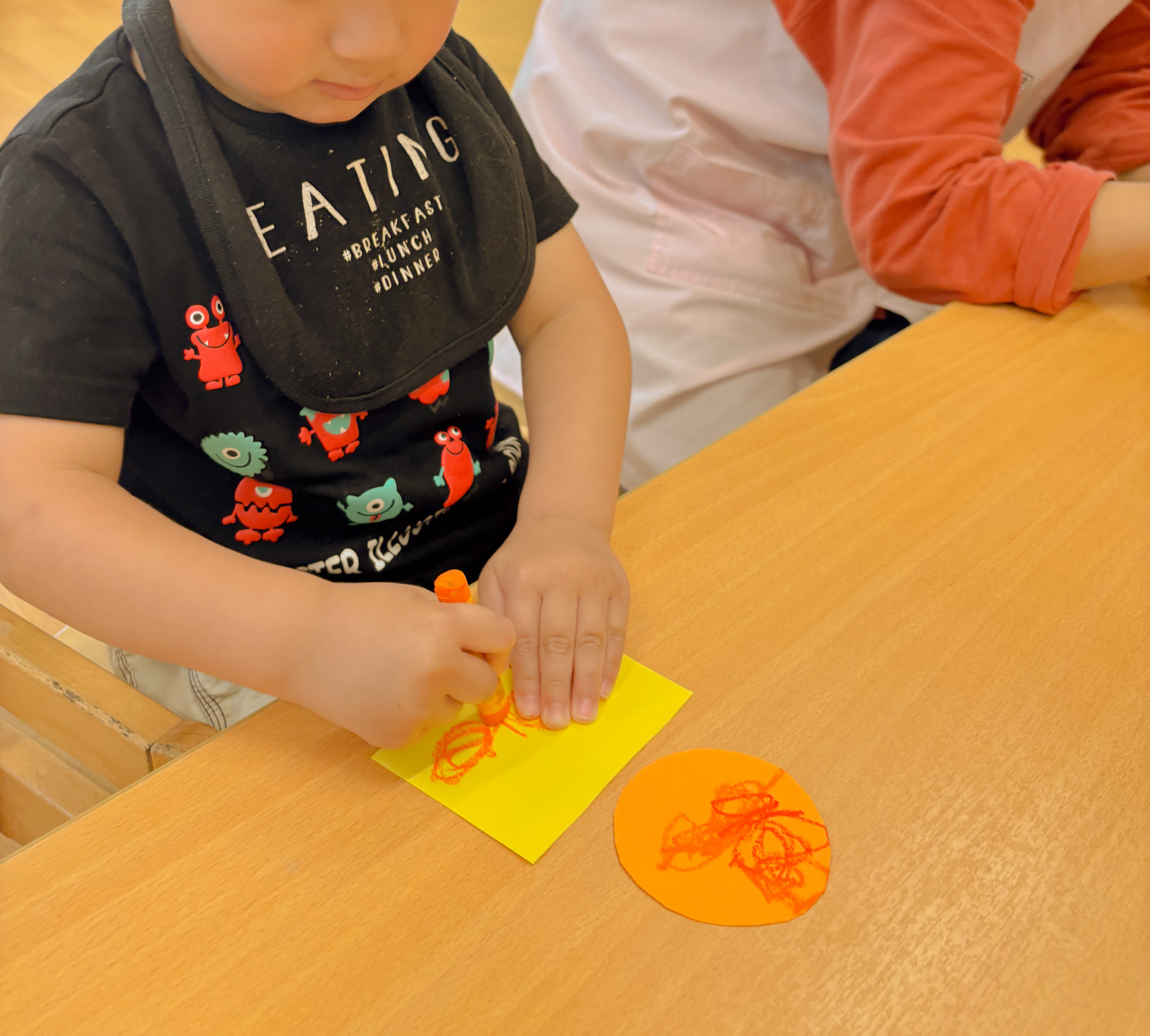 クレヨンでお金のデザインをする子ども