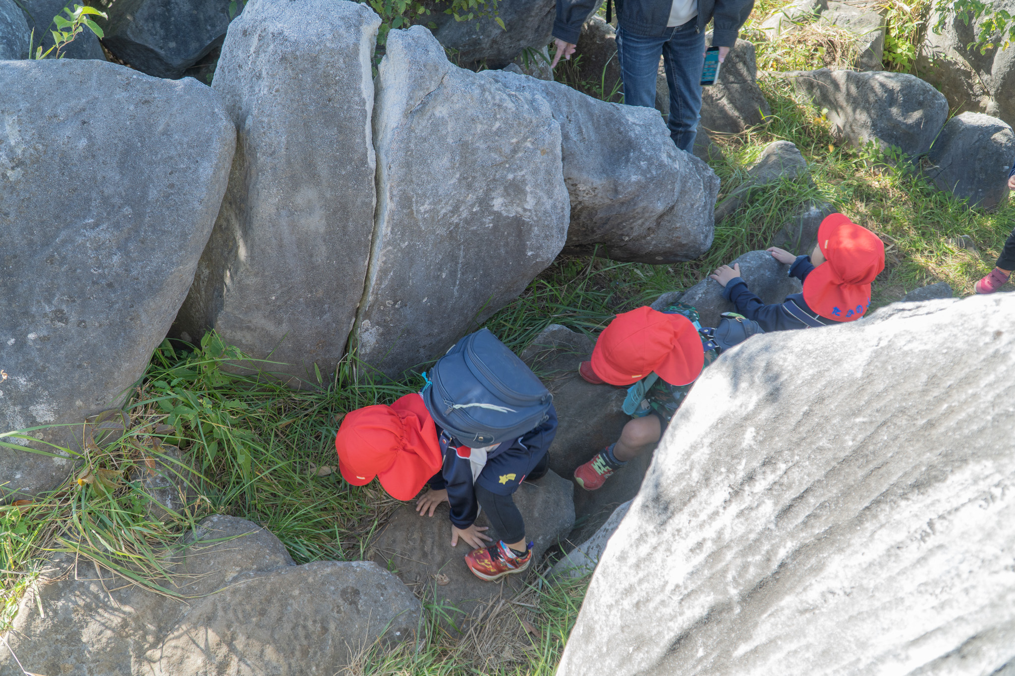 協力して岩場を進む子どもたち