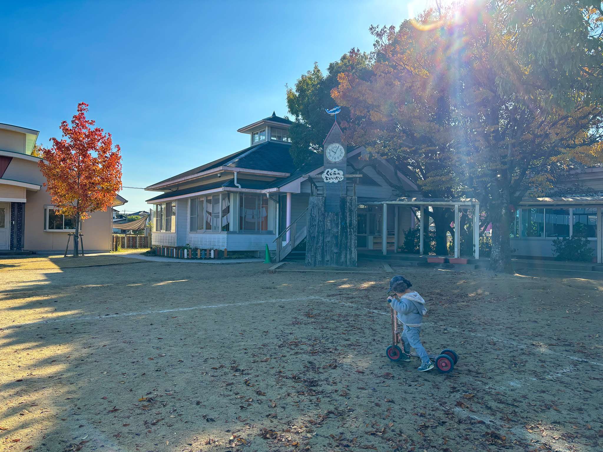 時計台のある園舎と遊ぶ子ども