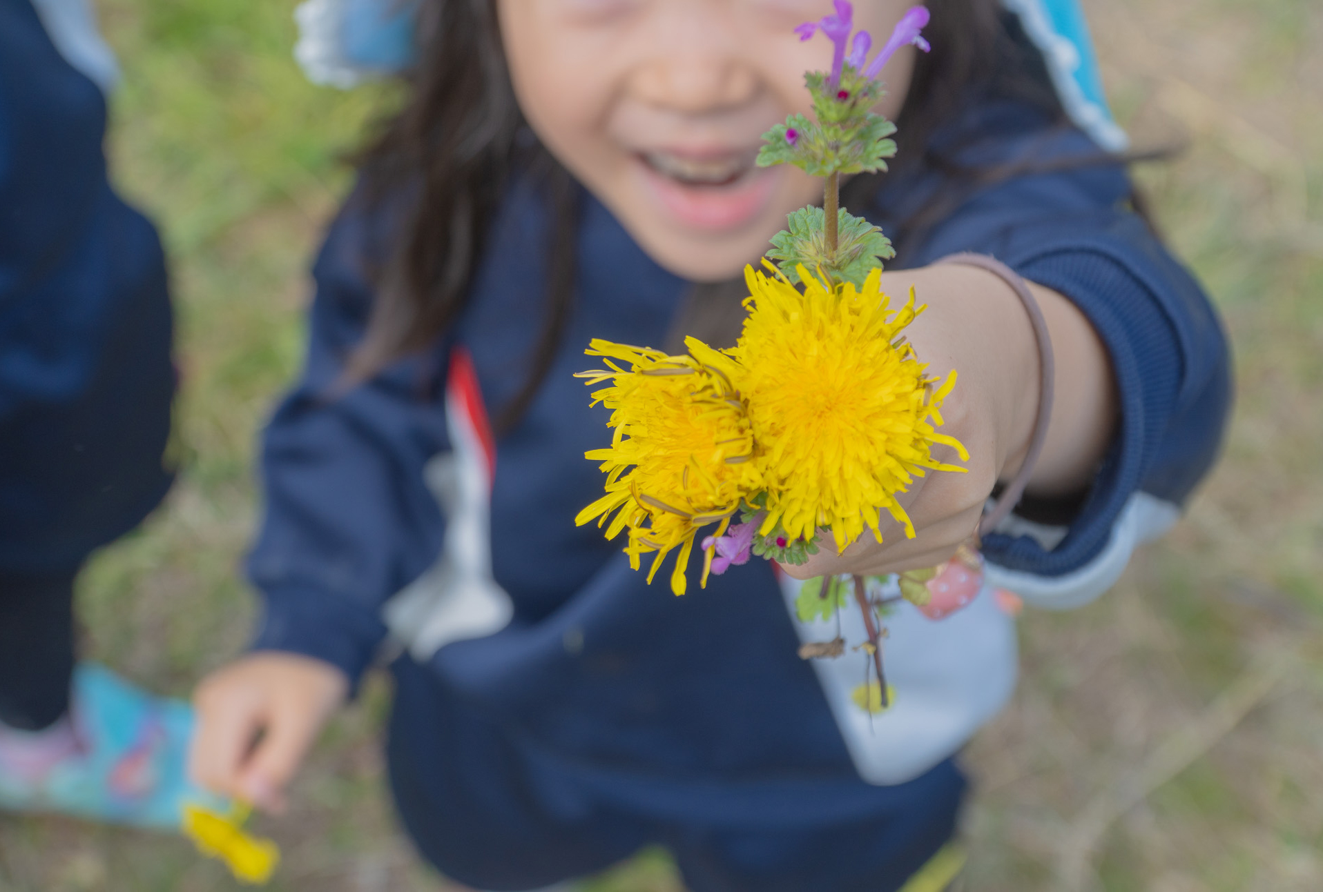 花を見せてくれる子ども